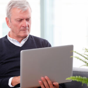 Retired professional working on a laptop